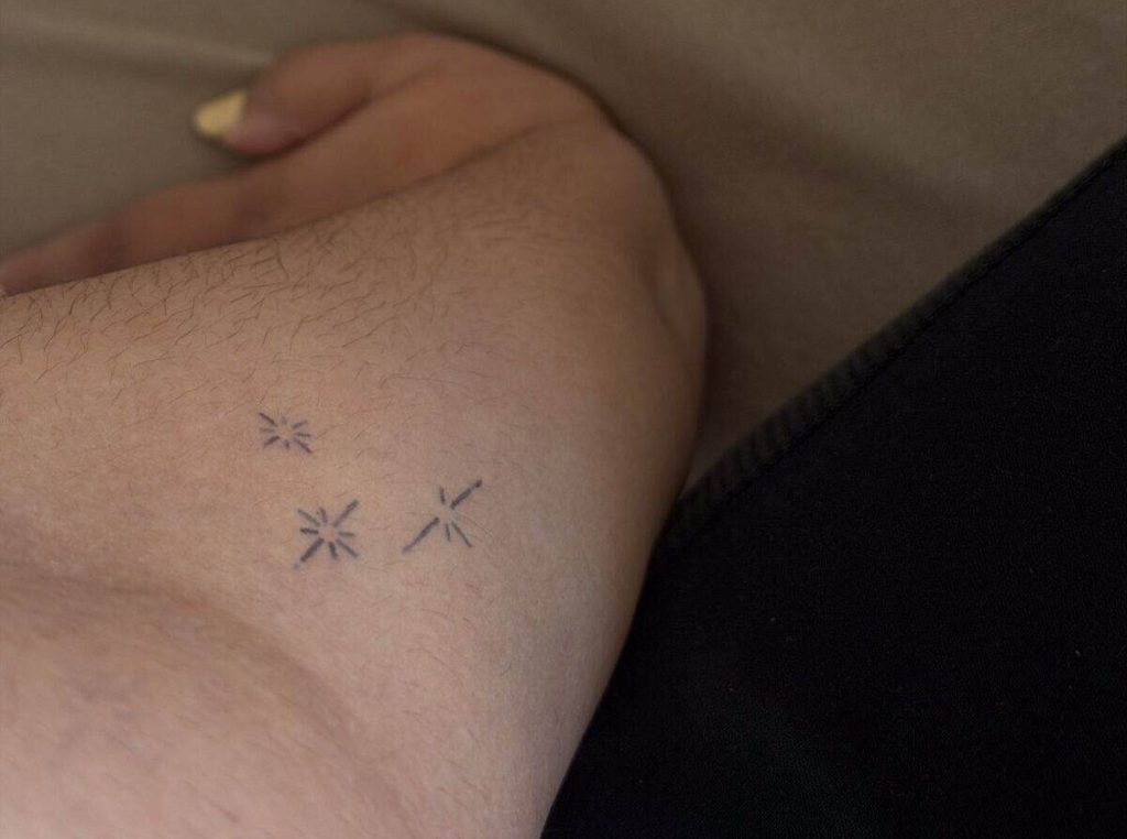 Three small celestial Inkster tattoos on the inner forearm after application