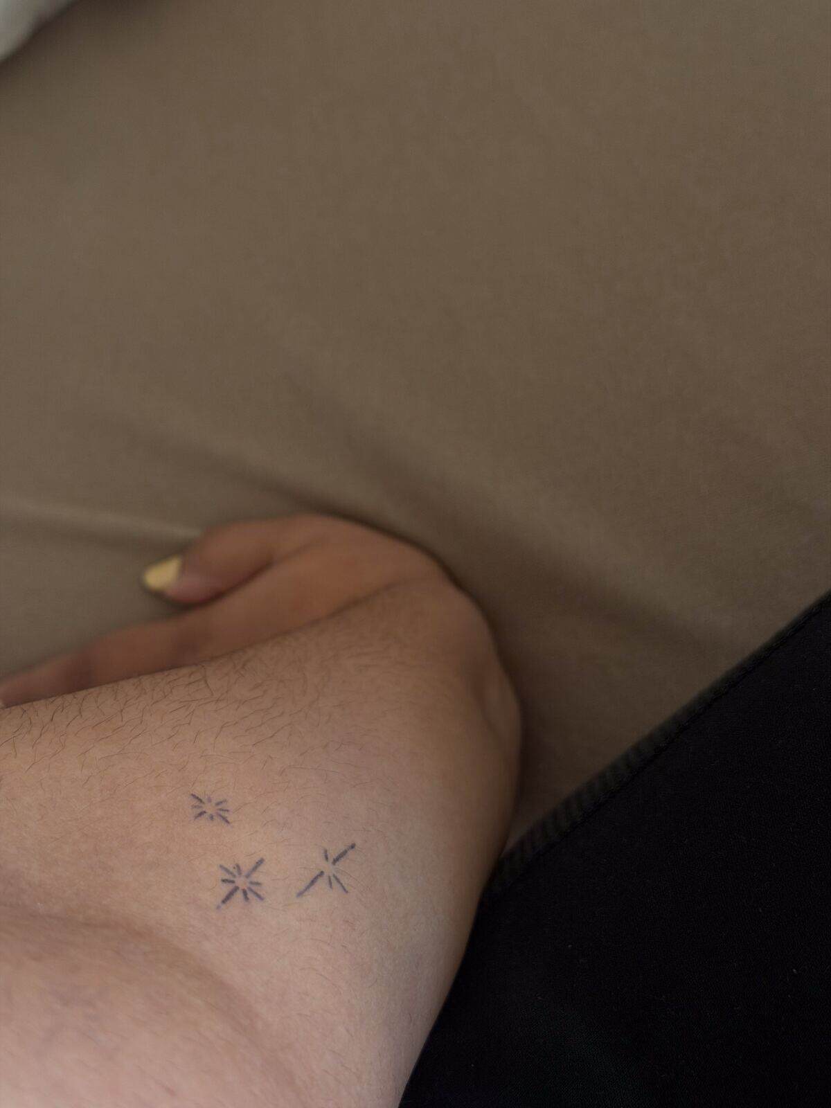 Three small celestial Inkster tattoos on the inner forearm after application