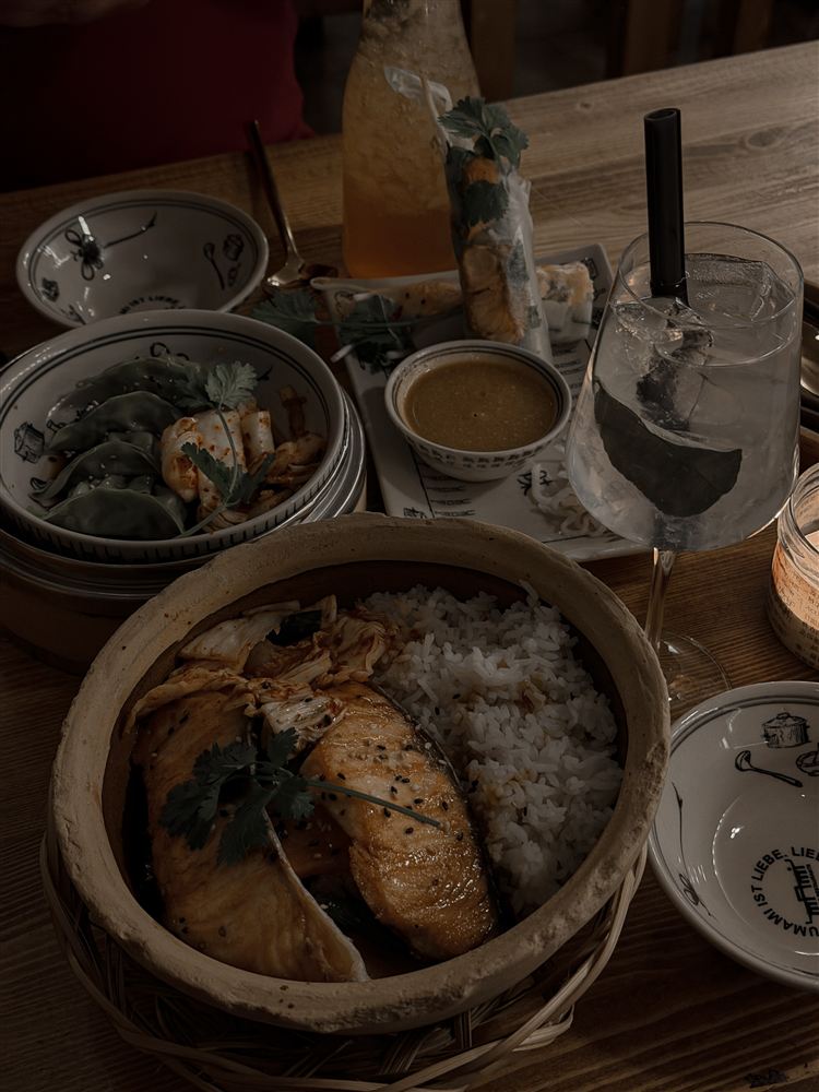 Grilled salmon and rice in a clay pot, with dumplings, summer rolls and drinks at Umami Ku’damm in Berlin.